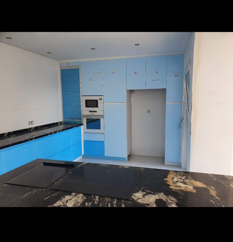 Cocina azul con isla de mármol negro — Reformas Kevin Benidorm